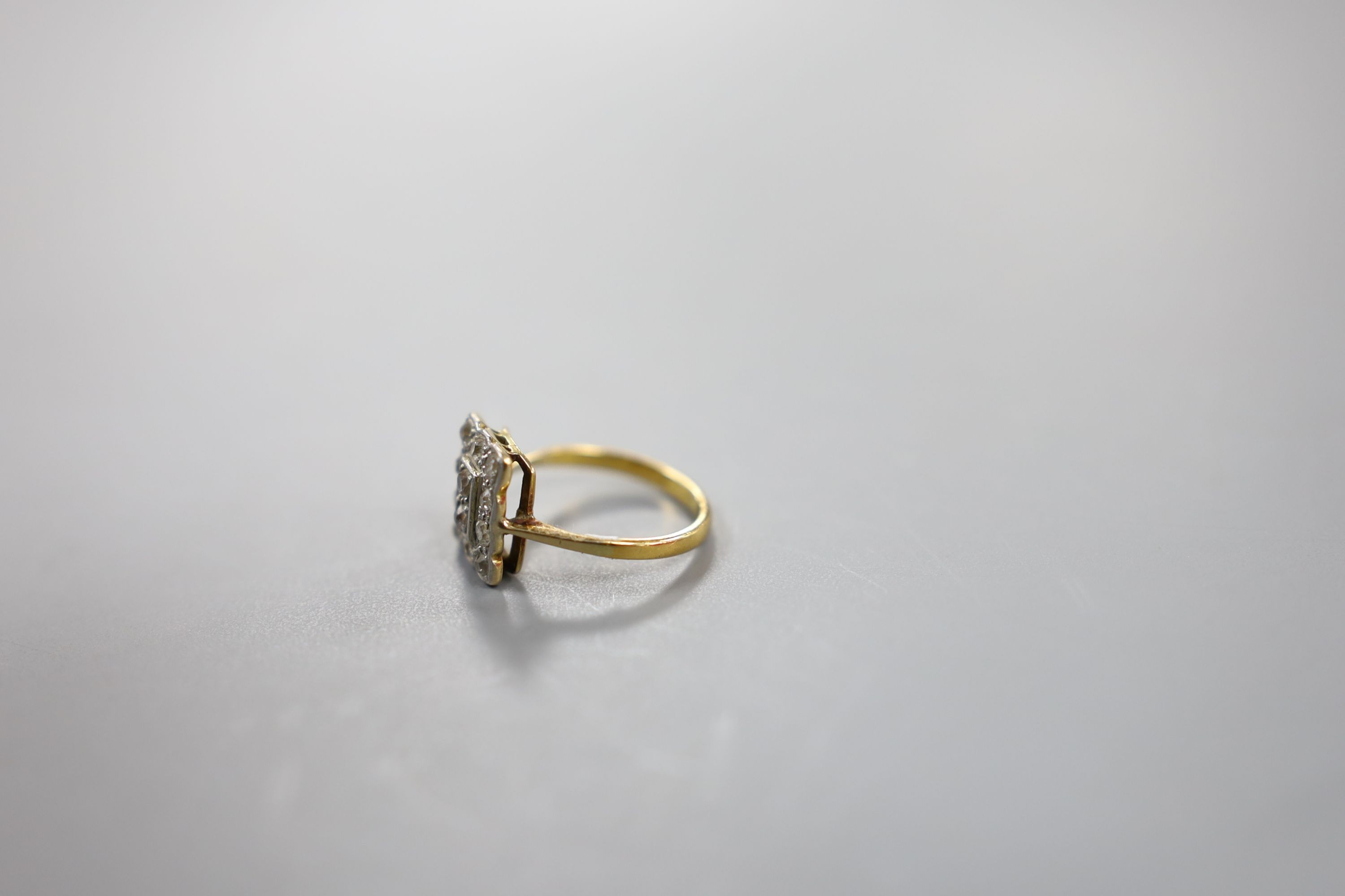 A 1920's yellow metal and diamond cluster set tablet ring, size F, gross weight 2.3 grams.